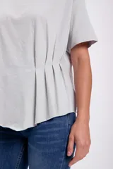 Remera gris claro de corte holgado con detalle de frunces en el lateral.