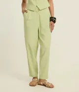 Pantalón zanahoria de vestir color verde claro, de tiro alto, con pliegues y bolsillos laterales.