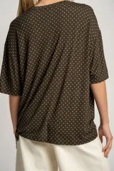 Remerón oversize color verde militar con estampado de lunares blancos, de mangas cortas y cuello redondo.