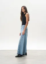 Pantalón de jean celeste de corte mega wide, con cintura alta y ruedo desflecado.