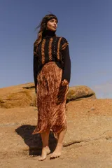 Sweater tejido a mano de algodón con cuello alto y diseño con rayas diagonales en color naranja y detalles en cuero natural.