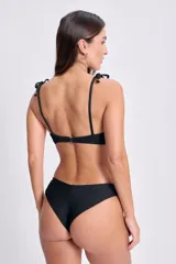 Top de bikini negro con textura arrugada y tirantes finos con detalle de nudo.