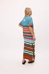 Vestido largo tejido a rayas horizontales de colores: azul, celeste, naranja, marrón, amarillo y verde. Tiene mangas cortas, cuello redondo y tajos laterales.