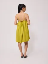 Vestido corto de algodón y lino color negro, con tirantes finos y escote recto con lazo ajustable.