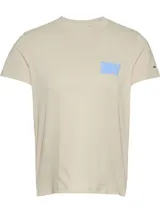 Remera color crema de algodón con cuello redondo y logo Tommy Jeans estampado en el pecho en color celeste. Tiene un parche con el logo de Tommy Jeans en la manga.