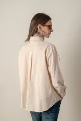 Camisa blanca de manga larga con dos bolsillos frontales con solapa.