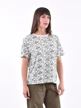 Remera blanca con estampado abstracto en tonos grises y negros.
