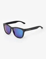 Gafas de sol unisex Hawkers, con montura cuadrada negra con textura y lentes espejados azules.