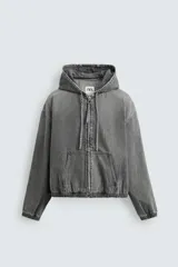 Cazadora gris de algodón con efecto lavado, corte relaxed fit, cuello con capucha ajustable, manga larga, bolsillos frontales tipo canguro, acabados con elástico y cierre frontal de cremallera.