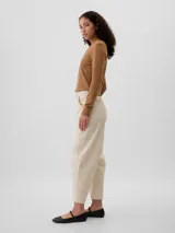 Pantalón color gris con corte amplio, bolsillos laterales y traseros, y ruedo al tobillo.