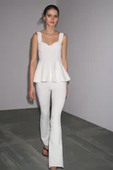 Top blanco de tejido elástico, con escote redondo, tirantes anchos y bajo peplum.