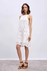 Vestido corto blanco de broderie con breteles finos y corte recto.