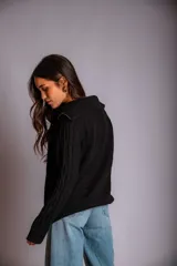 Buzo de punto color rosado, con cuello polo y cierre frontal parcial, de manga larga y diseño holgado.