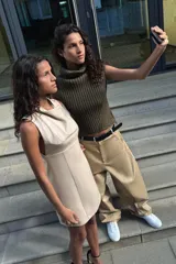Vestido corto color beige, sin mangas y con cuello drapeado.