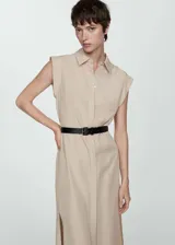 Vestido camisero midi color beige, sin mangas, con cuello camisero, cinturón ajustable y aberturas laterales.