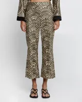 Pantalón negro con estampado dorado de motivos geométricos, corte flare y tiro alto.