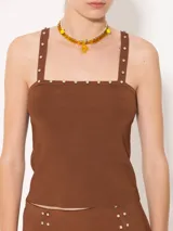 Top negro ajustado al cuerpo, con breteles finos y detalle de piedras en el escote.