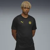 Camiseta de entrenamiento Puma del Club Atlético Peñarol, temporada 2024. Diseño negro con sutil estampado geométrico, logo de Puma en amarillo y escudo del club en el pecho.