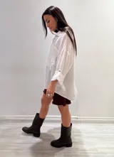 Camisa oversize rosada de lino, con cuello clásico, cierre frontal con botones, dos bolsillos de parche en el pecho y mangas largas con puños abotonados.