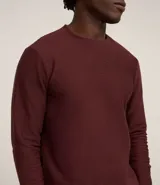 Remera marrón de manga larga con cuello redondo y textura acanalada.