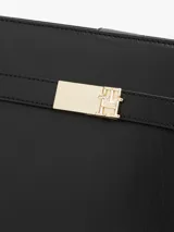 Cartera de hombro negra con correa fina ajustable y cierre dorado en la parte delantera.