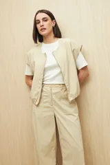 Pantalón color beige de corte ancho y tiro alto, con bolsillos delanteros amplios.