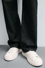 Zapatillas urbanas de cuero color blanco, con cordones y suela de goma con plataforma.