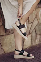 Sandalias negras de cuero con plataforma beige y doble tira con hebilla.
