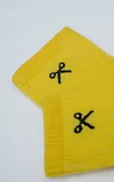 Medias amarillas de algodón con logo de Luxo en la botamanga y estampado con la frase "Ropa sin género para seres humanos".