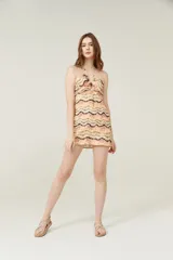 Minivestido con estampado zig-zag en tonos beige, naranja y marrón, con escote halter y espalda descubierta.