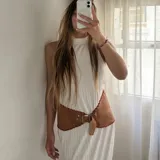 Faja ancha de cuero color camel con bordes festoneados y costura de tiento rojo. Posee hebilla metálica de estilo vintage.