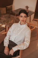 Camisa a cuadros marrón y beige, de algodón con cuello y pechera de tul bordado. Tiene botones de nácar en la cartera y los puños.