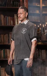 Remera gris con efecto lavado, de corte oversize y manga corta. Estampado frontal con diseño de estilo tarot con estrellas, figuras femeninas y plantas.