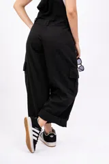 Enterito largo negro con breteles regulables, corte holgado, bolsillos laterales y ruedo arremangado.