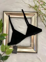 Bralette negro de lycra con corte triangular, breteles regulables y cierre trasero con gancho.