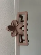 Broche para el pelo color rosa nude con forma rectangular y aplique de flor.