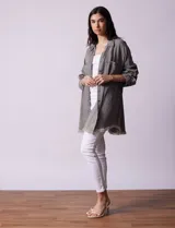 Camisa de jean celeste, marca Hester & Orchand, de corte oversize con cuello con solapa, escote en V y abertura central con botones. Delantera con bolsillos aplicados, mangas largas regulables con presilla y botón, y ruedo desflecado.
