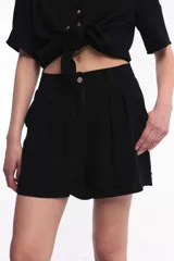 Short negro de tiro alto con pinzas delanteras, bolsillos laterales y ruedo con dobladillo.