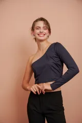 Top corto negro de un hombro con manga larga ajustada.