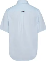 Camisa celeste de manga corta Tommy Hilfiger, confeccionada en algodón orgánico y nylon. Tiene cuello clásico, cierre frontal con botones, dobladillo curvo y logo bordado en el pecho.
