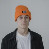 Gorro de lana blanco con etiqueta negra con el logo de la marca Pulau.