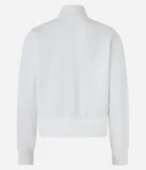 Chaqueta deportiva blanca con cierre frontal, cuello alto y puños ajustados. Presenta la inscripción "BERLIN" en letras negras y gruesas en el pecho.