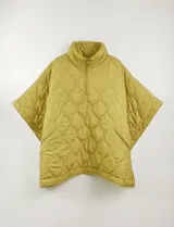 Poncho acolchado color mostaza con cuello alto y abertura frontal con cierre. Presenta un patrón capitoné de formas ovaladas y bolsillos delanteros.