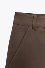 Shorts tiro bajo color negro con bolsillos delanteros. Cierre frontal con cremallera y ganchos metálicos.