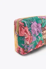 Neceser rectangular acolchado con estampado floral multicolor, cierre de cremallera y borla decorativa.
