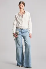 Jeans de tiro medio y bota wide leg. Confeccionado en tejido 100% algodón. Su proceso de lavado artesanal genera sofisticados tonos azules intensos y profundos.