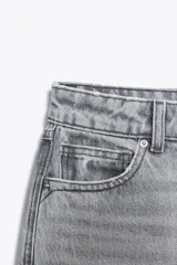 Pantalón de jean gris de corte recto, tiro alto y largo hasta el tobillo.