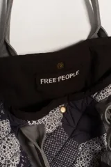 Bolso tipo tote amplio, confeccionado en patchwork de hexágonos con diferentes estampados en tonos azul marino y blanco/gris. Presenta asas y base en tela lisa gris. El cuerpo del bolso tiene un efecto acolchado.