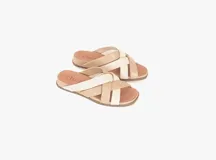 Sandalias bajas de cuero color beige con tiras cruzadas en cuero color blanco.