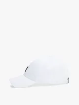 Gorra de béisbol blanca de algodón con diseño de seis paneles, ojales de ventilación, botón en la parte superior y hebilla de ajuste metálica en la parte trasera. Presenta un monograma TH bordado en negro en la parte delantera.